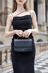 a lady in a black strap sheath dress